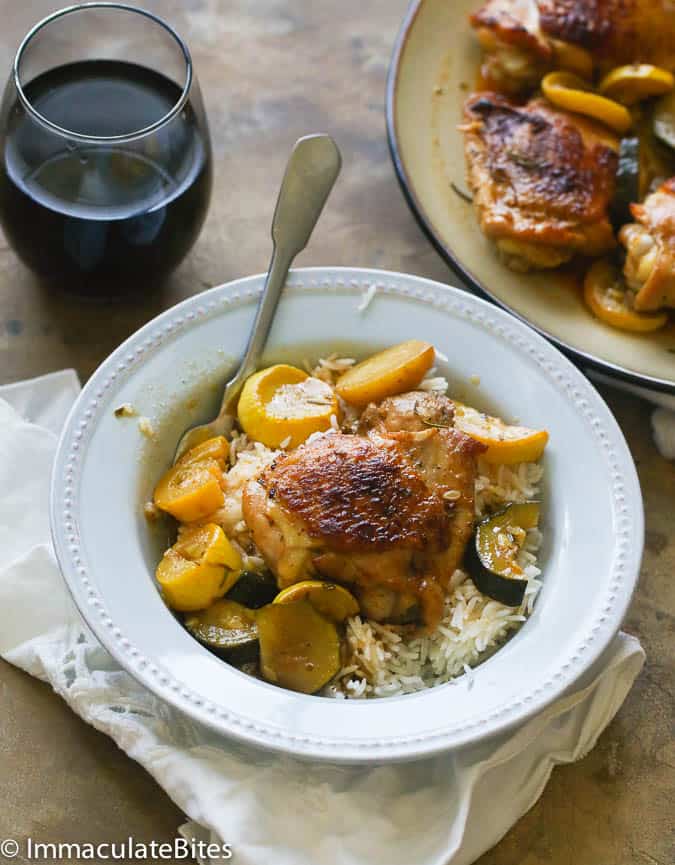 Enjoying a lemon rosemary chicken thigh over a bowl of steaming white rice