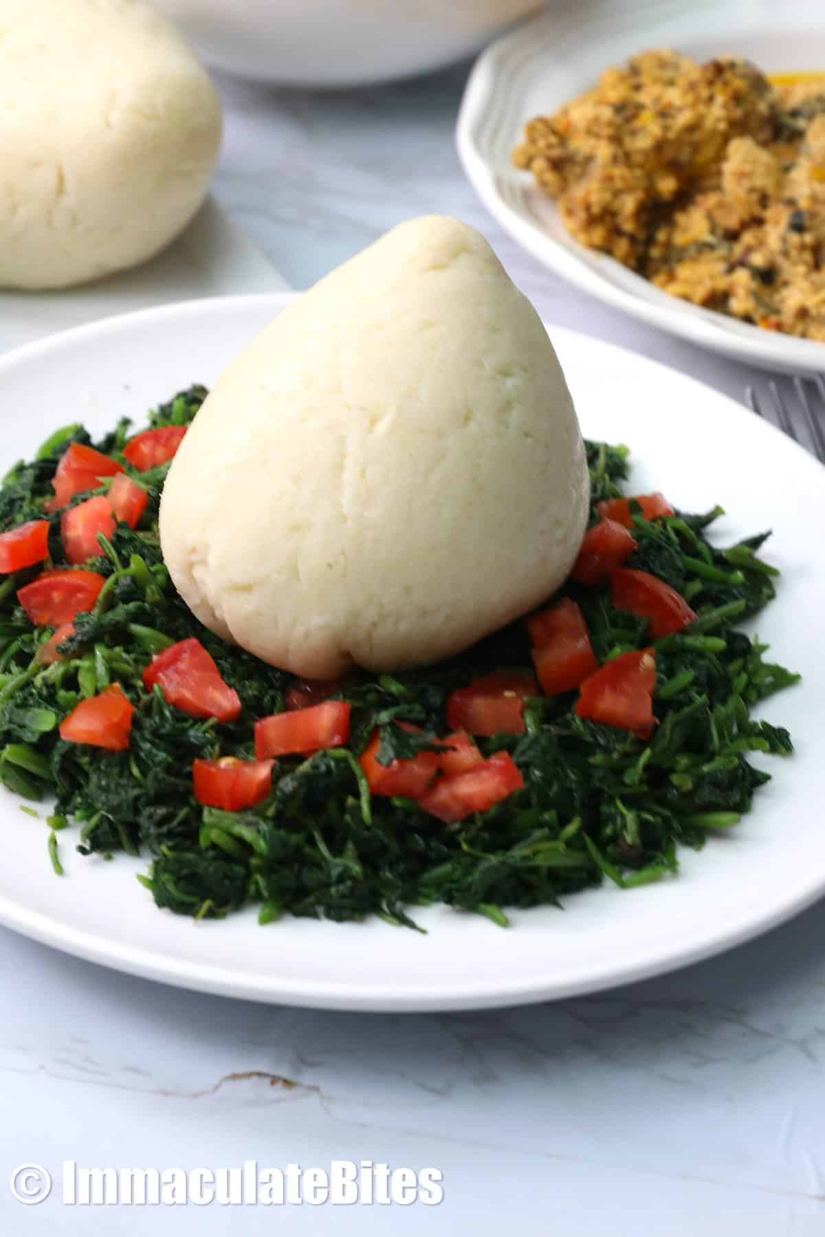 Ugali (corn fufu) on top a plateful of African-style greens
