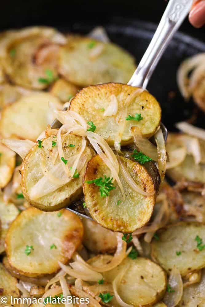 cooked potatoes and onions on a serving spoon