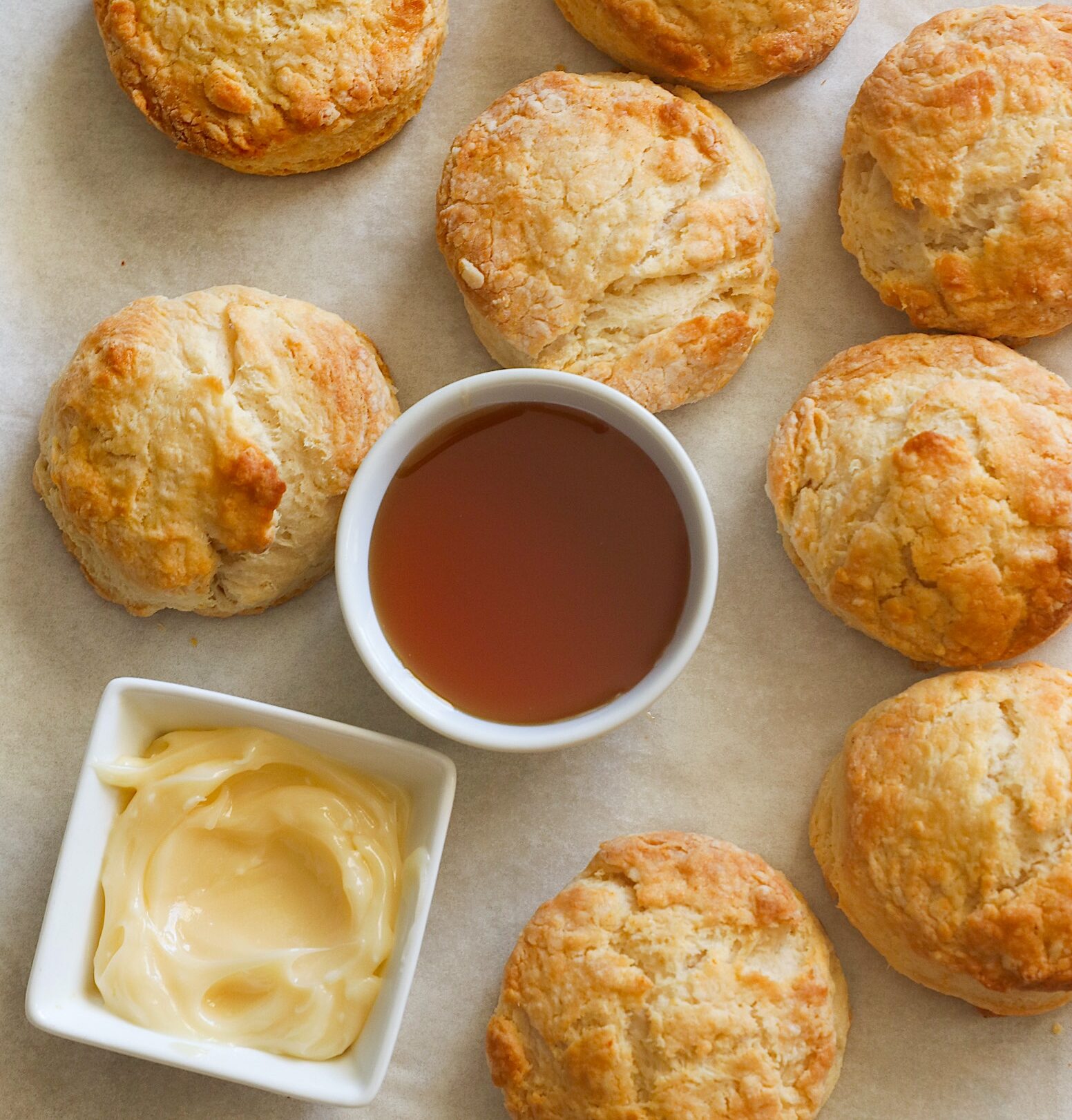 Insanely comforting Honey Butter Biscuits with honey butter and honey ready for drizzling. A must-have on your list of essential biscuit recipes