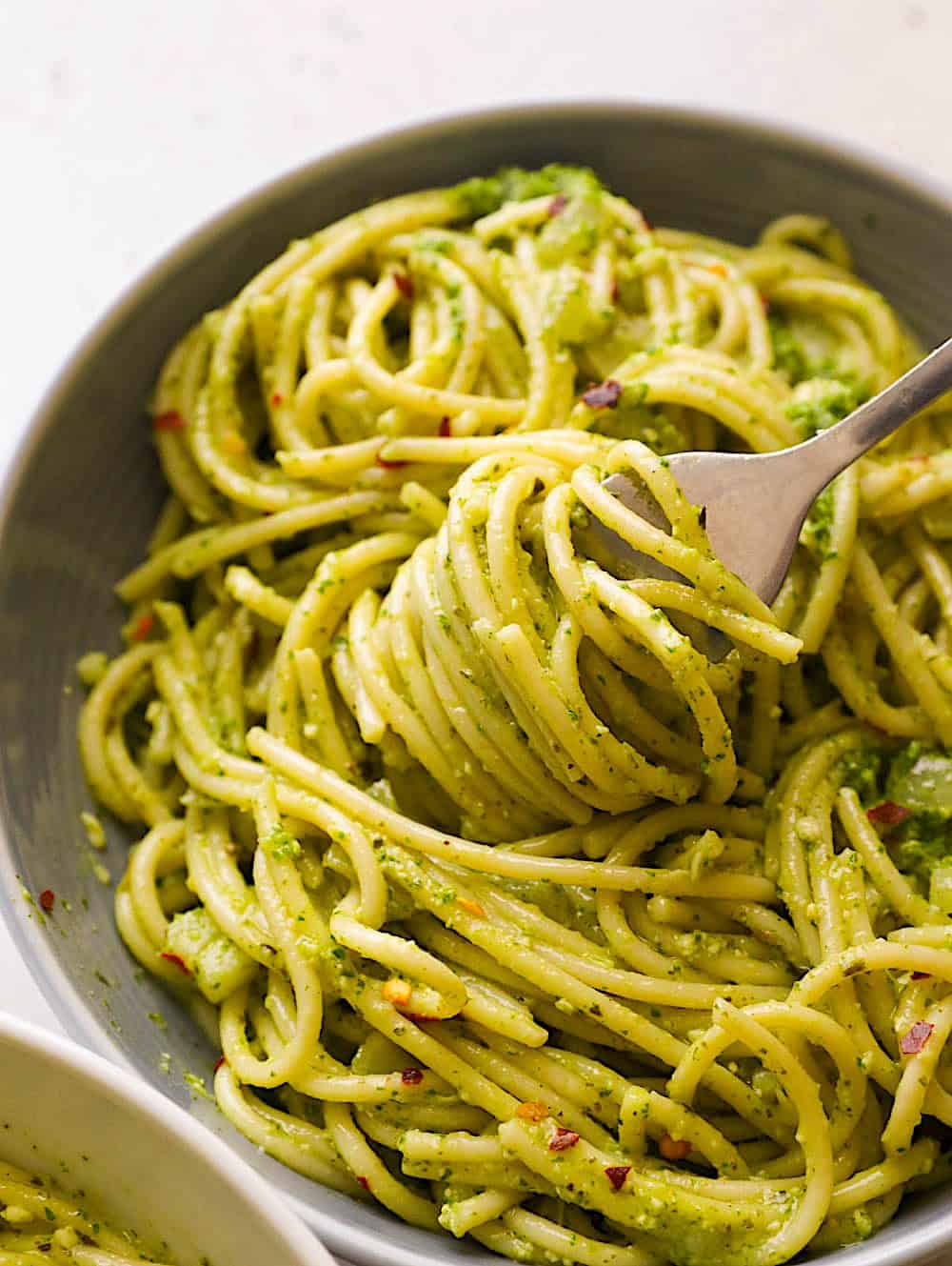 Spinning pasta on a fork, getting ready to take a tasty bite of pesto pasta