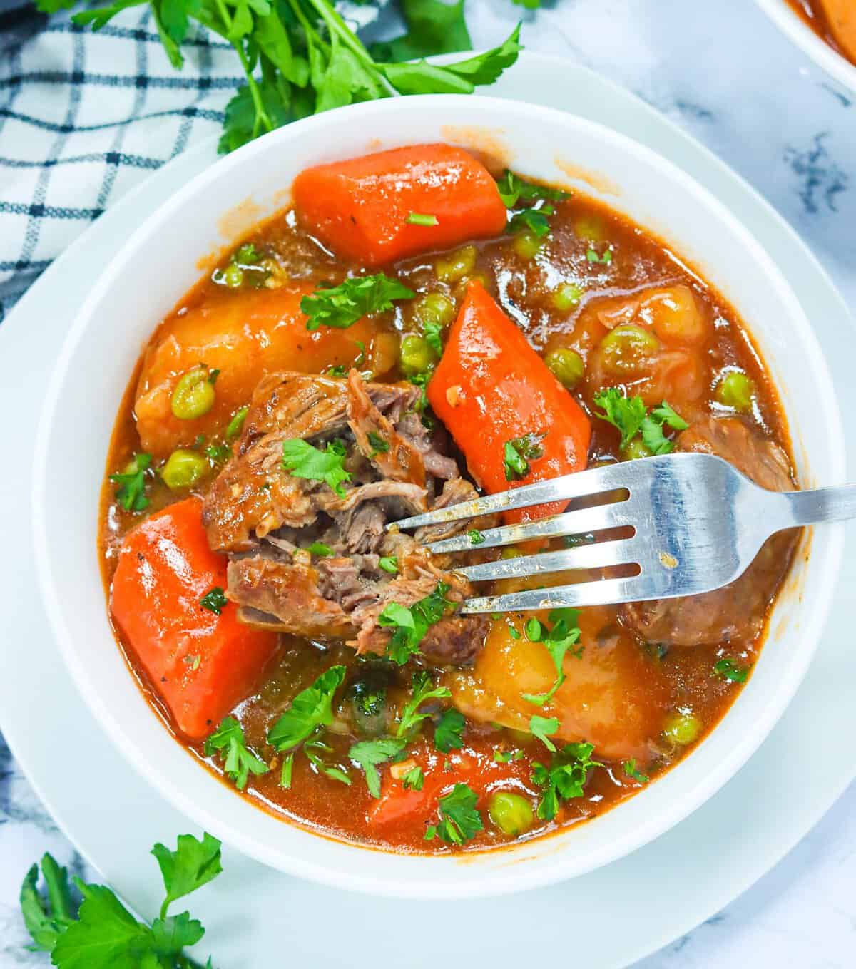 Diving into a hearty bowl of Dutch oven beef stew with a fork