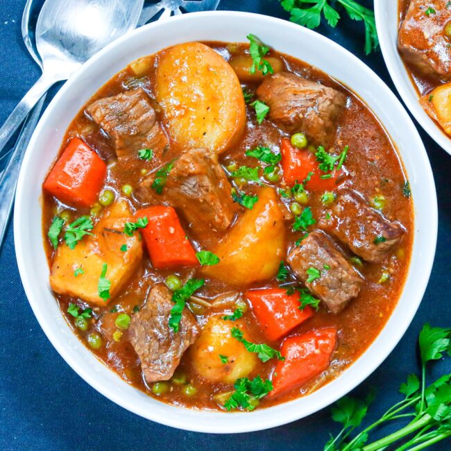 Two bowls of steaming beef stew made in a Dutch oven for pure satisfaction