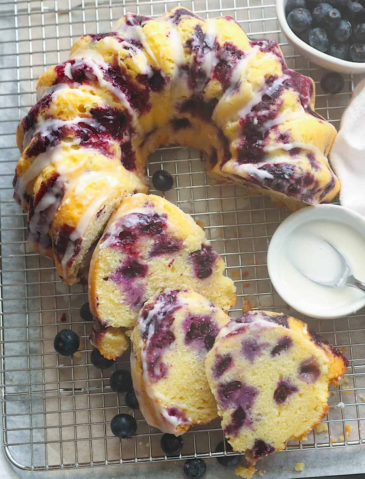 Slicing into a decadent blueberry bundt cake with extra glaze on the side for a lemony twist