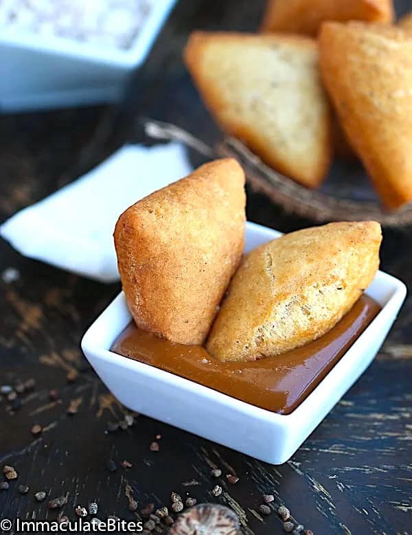 Dipping 2 easy mandazis in decadent caramel sauce for a soul food treat
