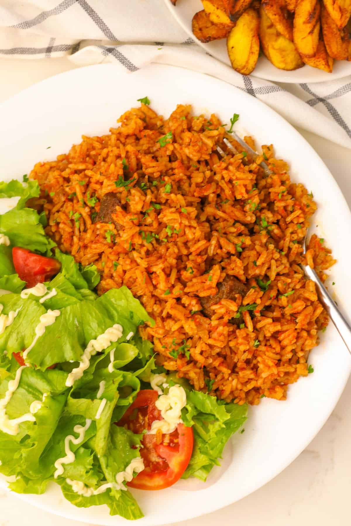 Serving up steaming hot jollof rice from Ghana with a refreshing green salad