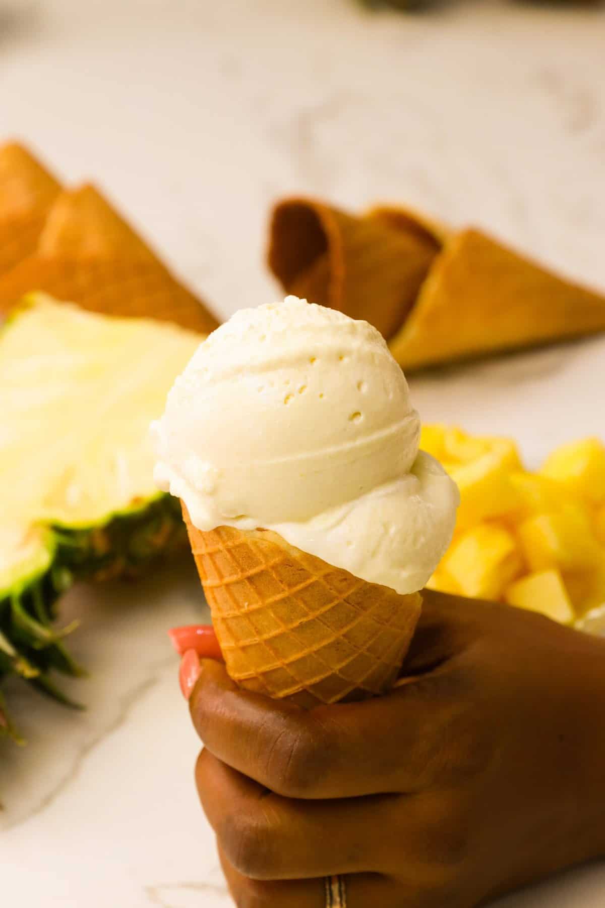 Filling a cone with tasty homemade pineapple ice cream