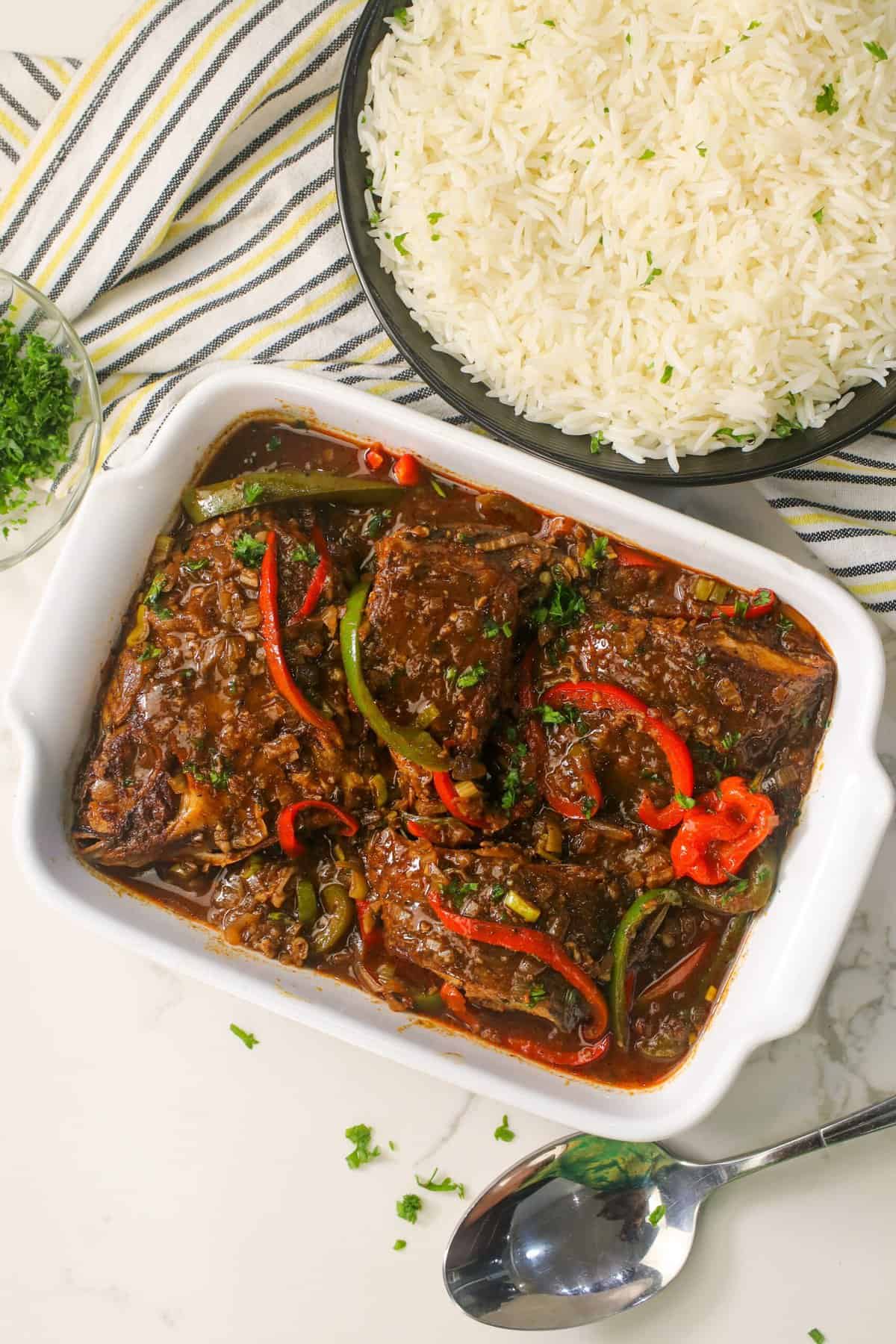 Serving up a platter of Jamaican brown stewed fish with steaming rice