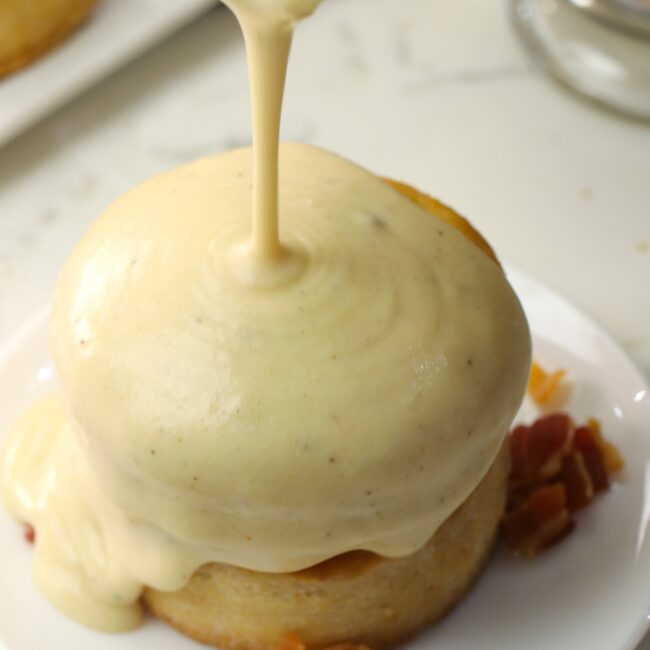 Pouring fresh bacon gravy over incredible homemade biscuits