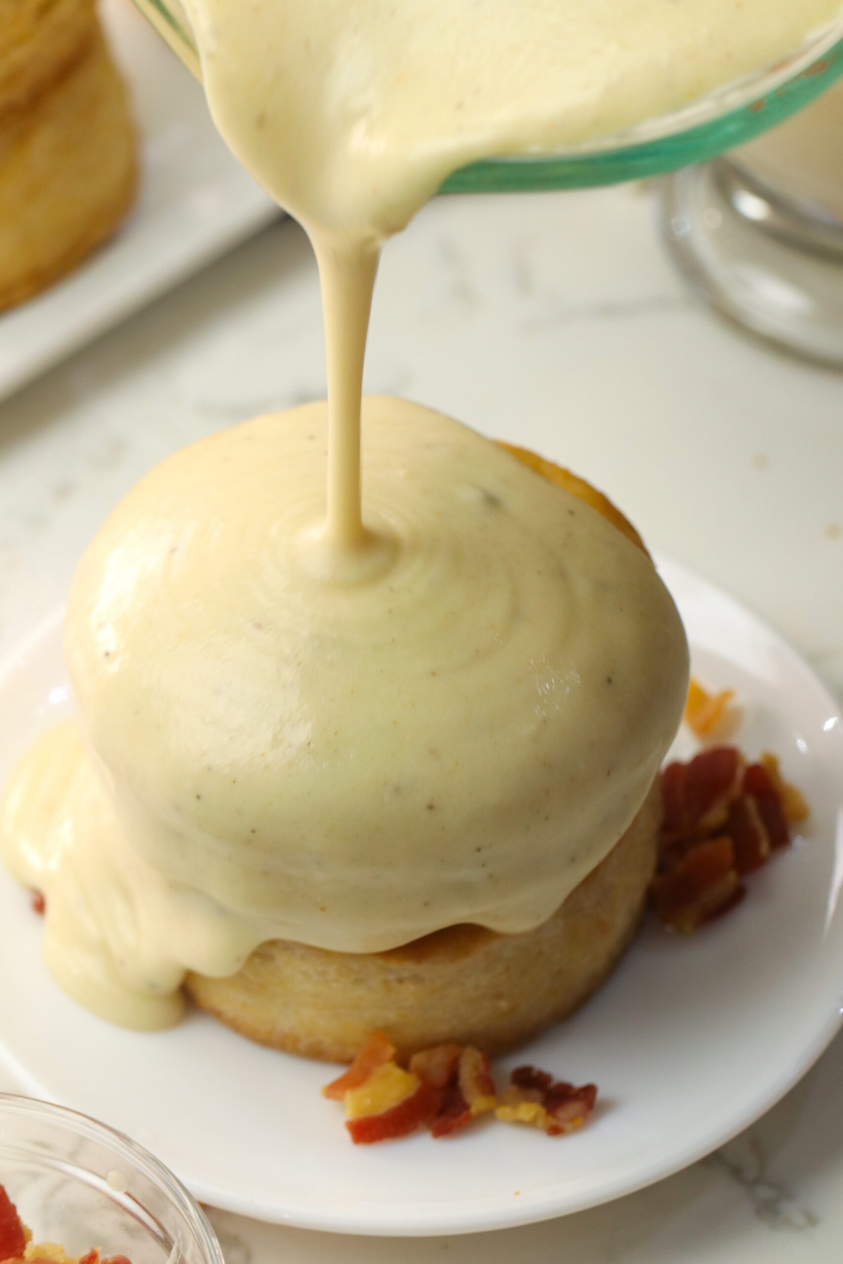 Pouring fresh bacon gravy over incredible homemade biscuits