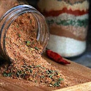 Spicy and flavorful Jamaican jerk seasoning spilling out of a glass jar and ready to spice up your meal