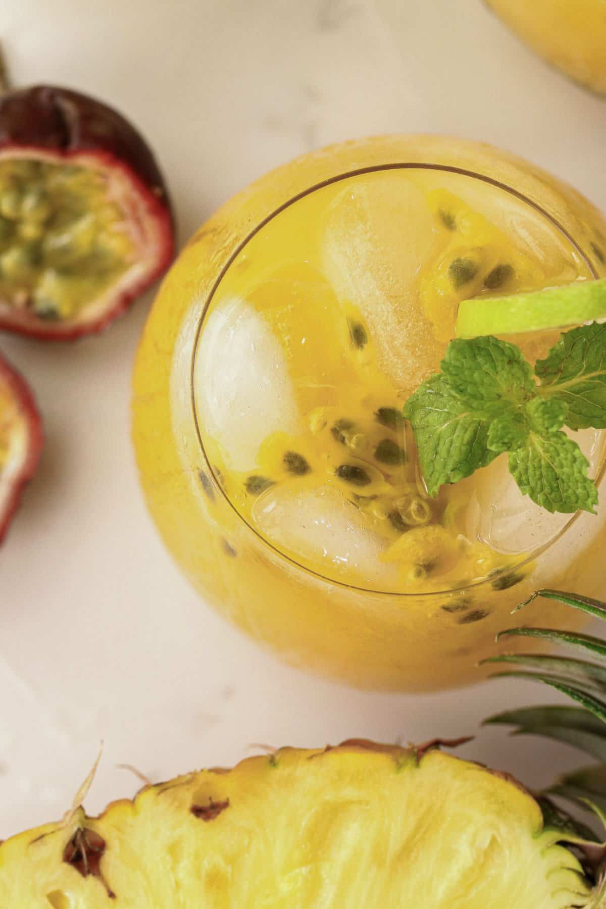 Looking down on a cool glass of pineapple passion fruit lemonade decorated with mint leaves