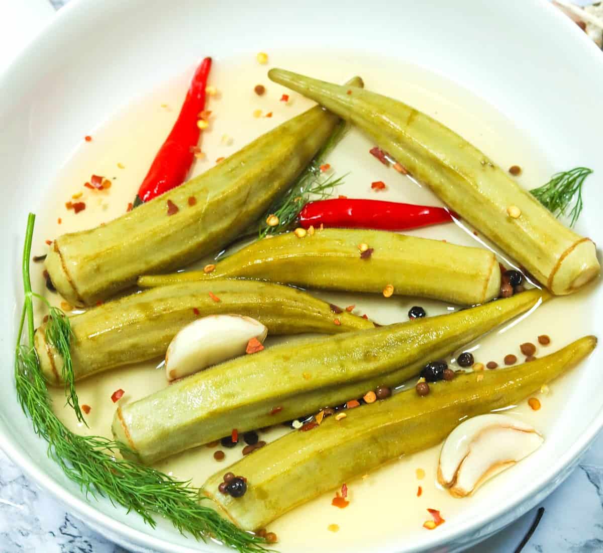 A bowlful of pickled okra with chili peppers for a delightful snack or condiment