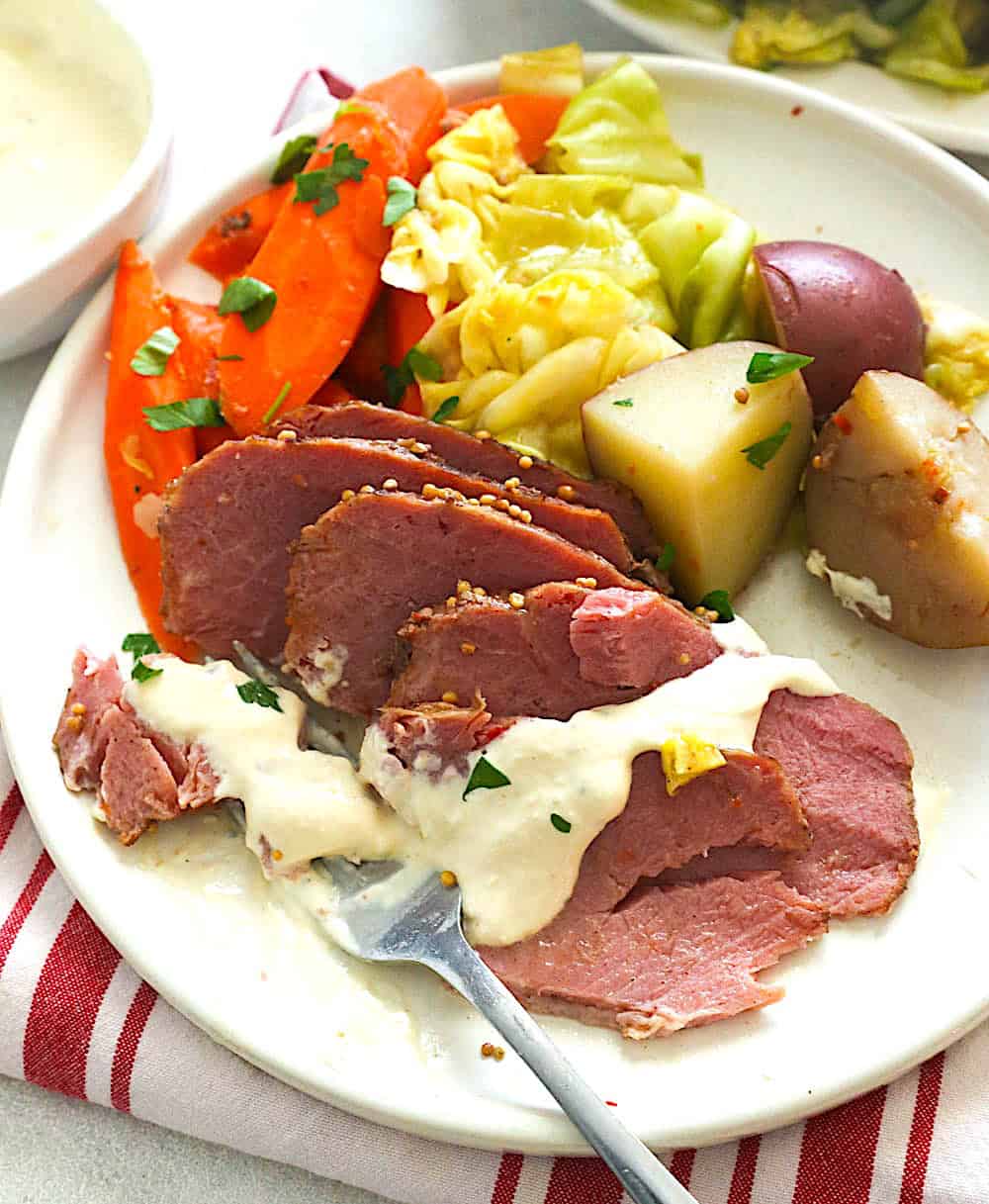 Drizzling slow cooker corned beef and cabbage drizzled with a delectable sauce