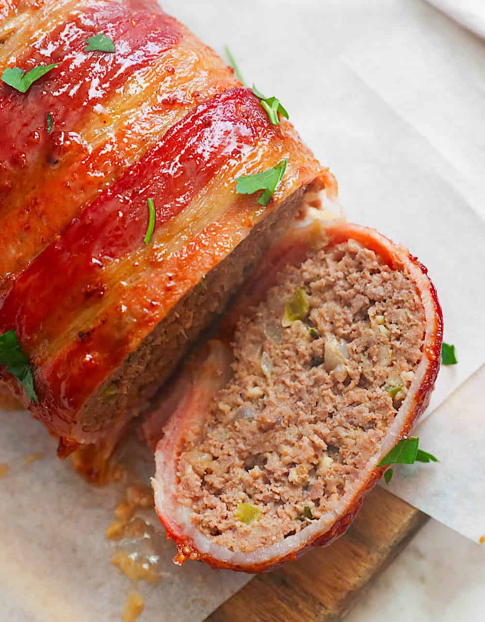 Showing of a slice of fresh, hot out of the oven bacon-wrapped meatloaf