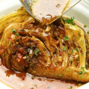 Drizzling a cabbage wedge with flavorful braising liquid