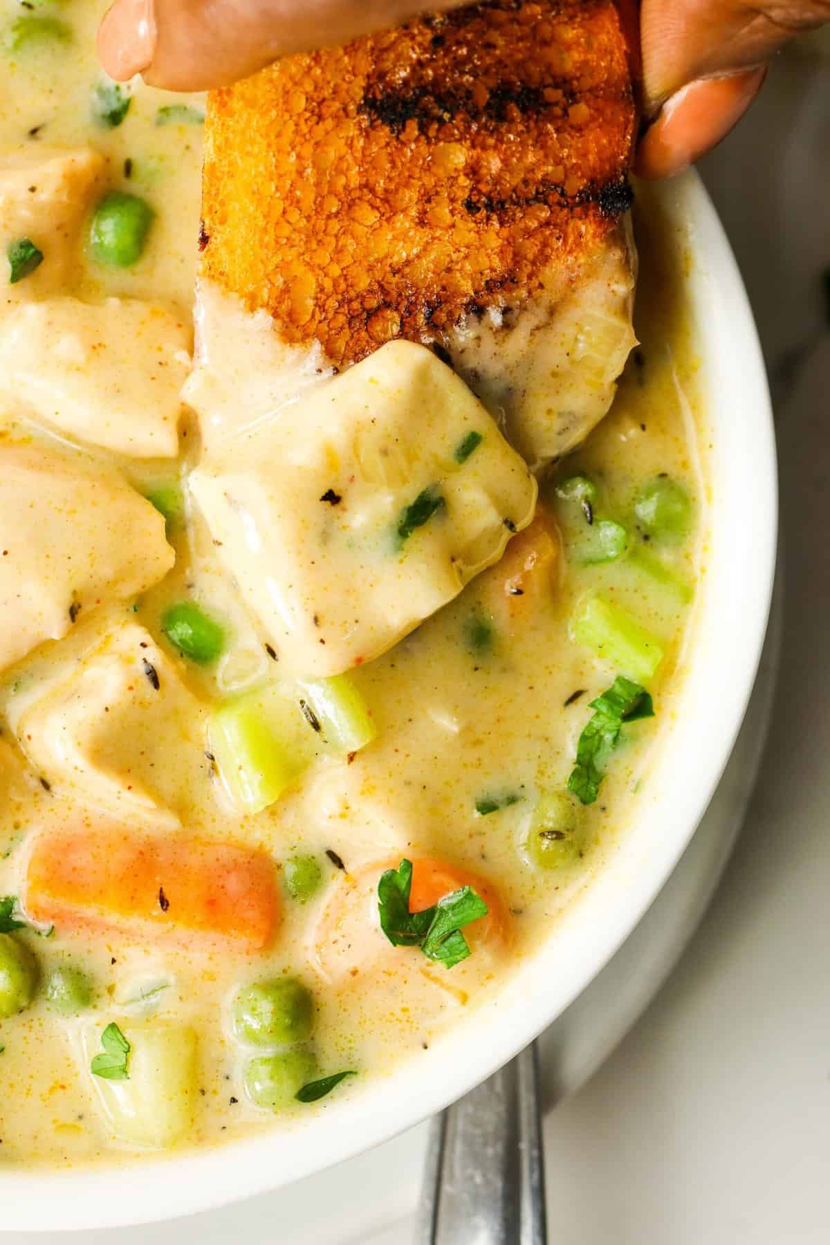 Diving into a bowl of satisfying chicken pot pie soup with homemade bread