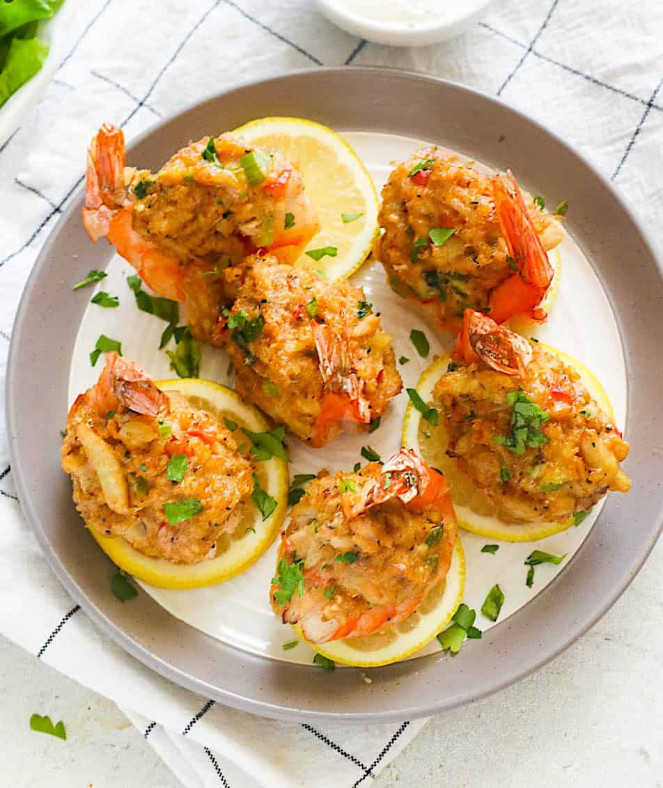 A perfect appetizer with a plate full of shrimp stuffed with crab and lemon slices