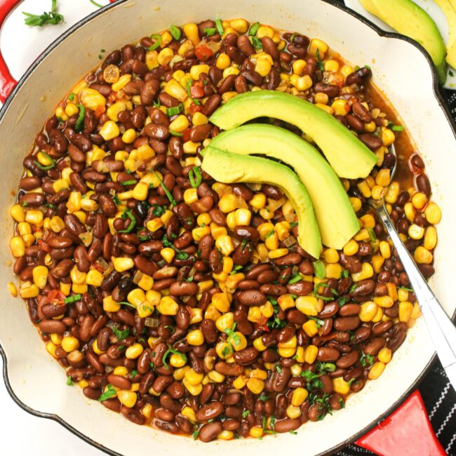 Getting ready to serve freshly made githeri with avocado slices