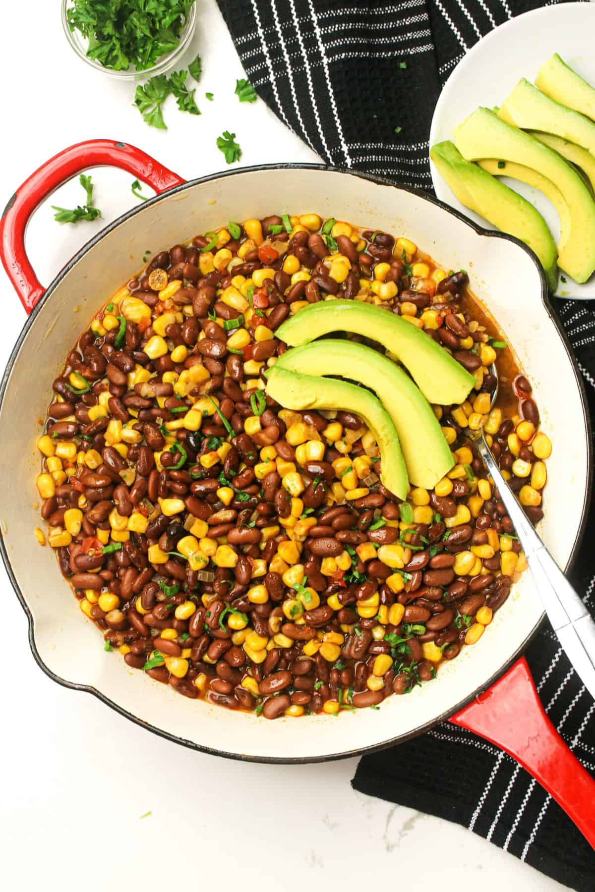 Getting ready to serve freshly made githeri with avocado slices