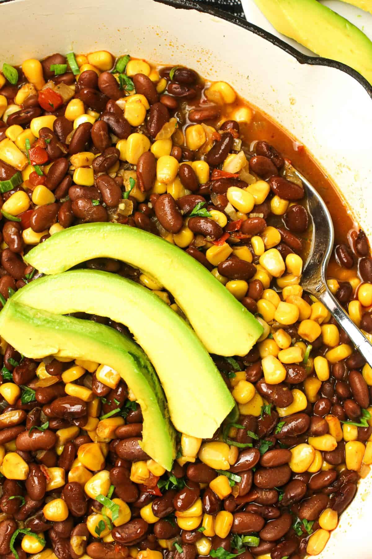 Serving up corn and bean githeri with avocado slices for a highly nutritious meal