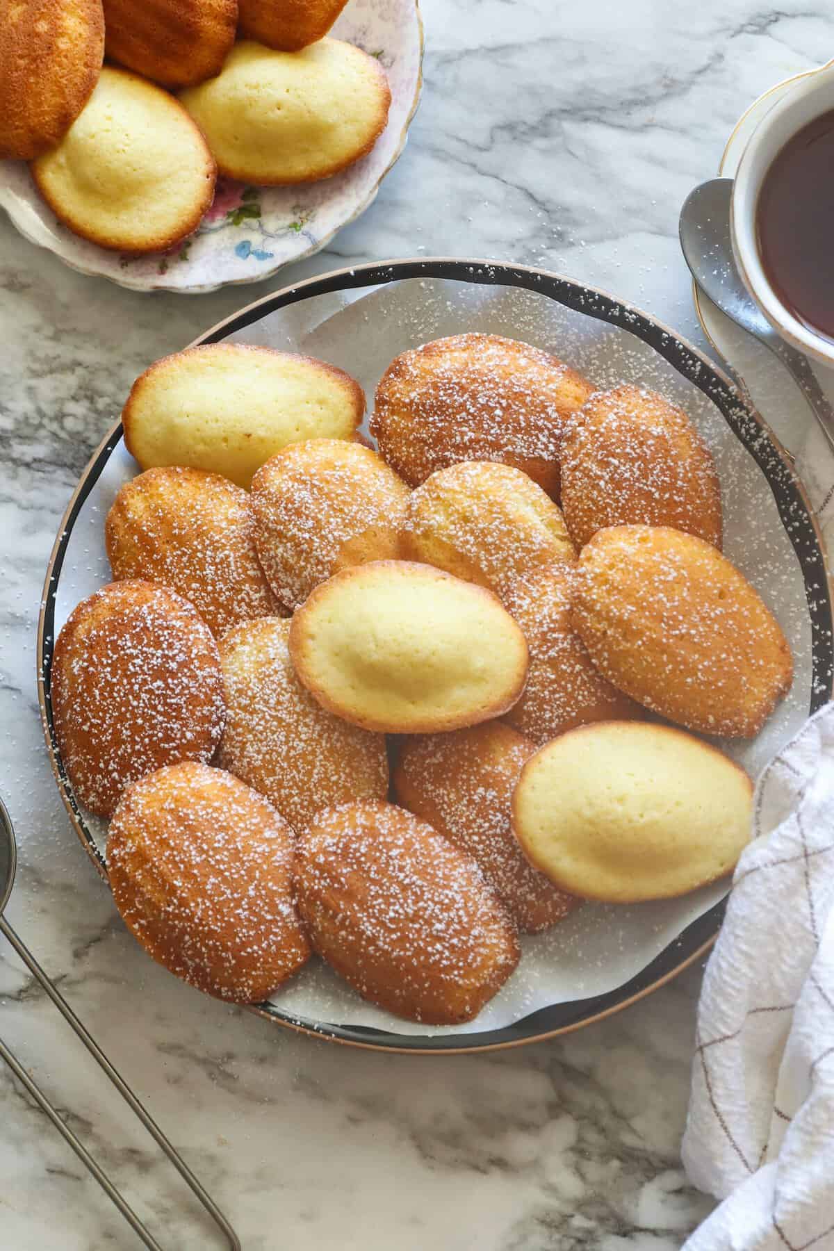 A plateful of madeleine cookies (cakes) ready to enjoy with a cup of coffee