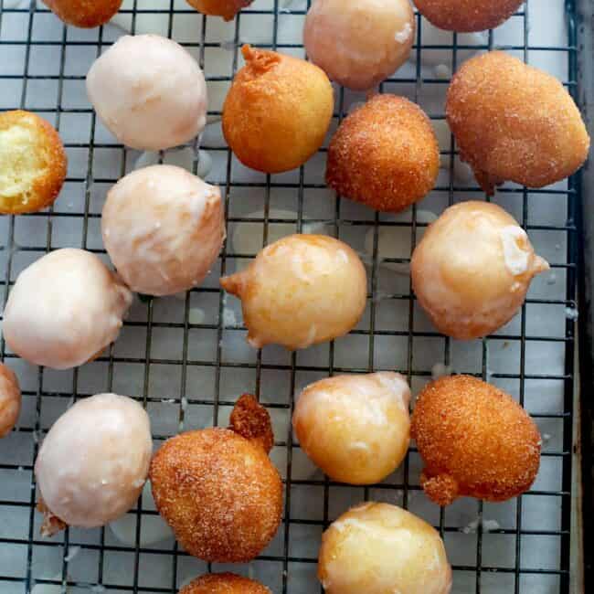 Freshly glazed donut holes with some covered in cinnamon sugar