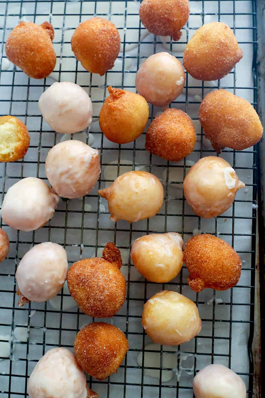 Freshly baked donut holes, some covered with cinnamon sugar