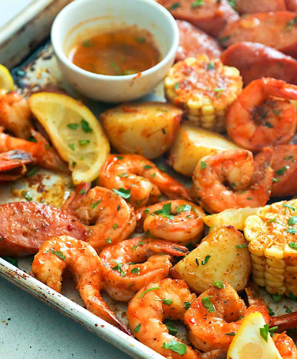 Serve a pot of Cajun shrimp boiling with potatoes, corn, sausages and spice butter