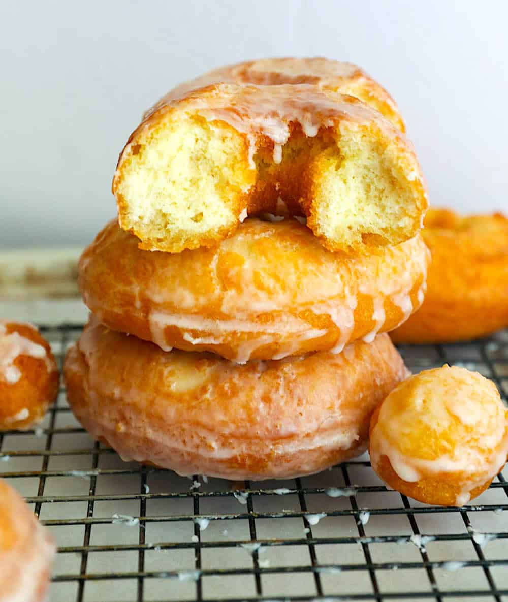 Taking a bite out of a decadently warm old fashioned cake doughnut