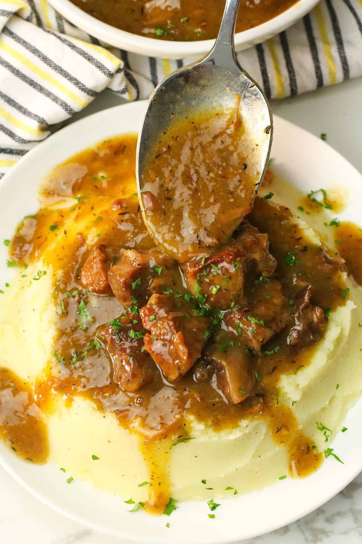 Smothering creamy mashed potatoes with steaming slow cooker beef tips