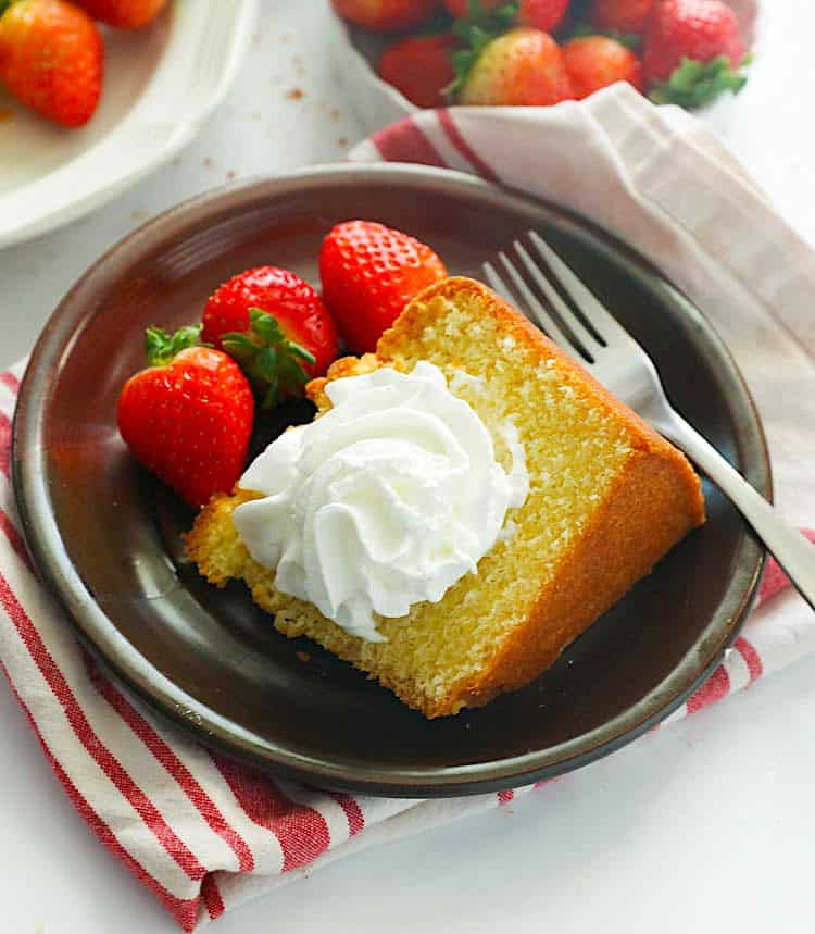 Enjoying a slice of Southern pound cake with fresh strawberries and a dollop of homemade whipped cream